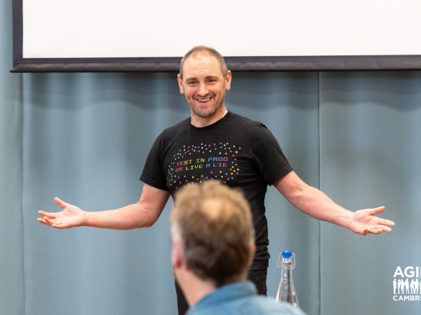 A speaker hosting a session, you can see the back of the audiences heads